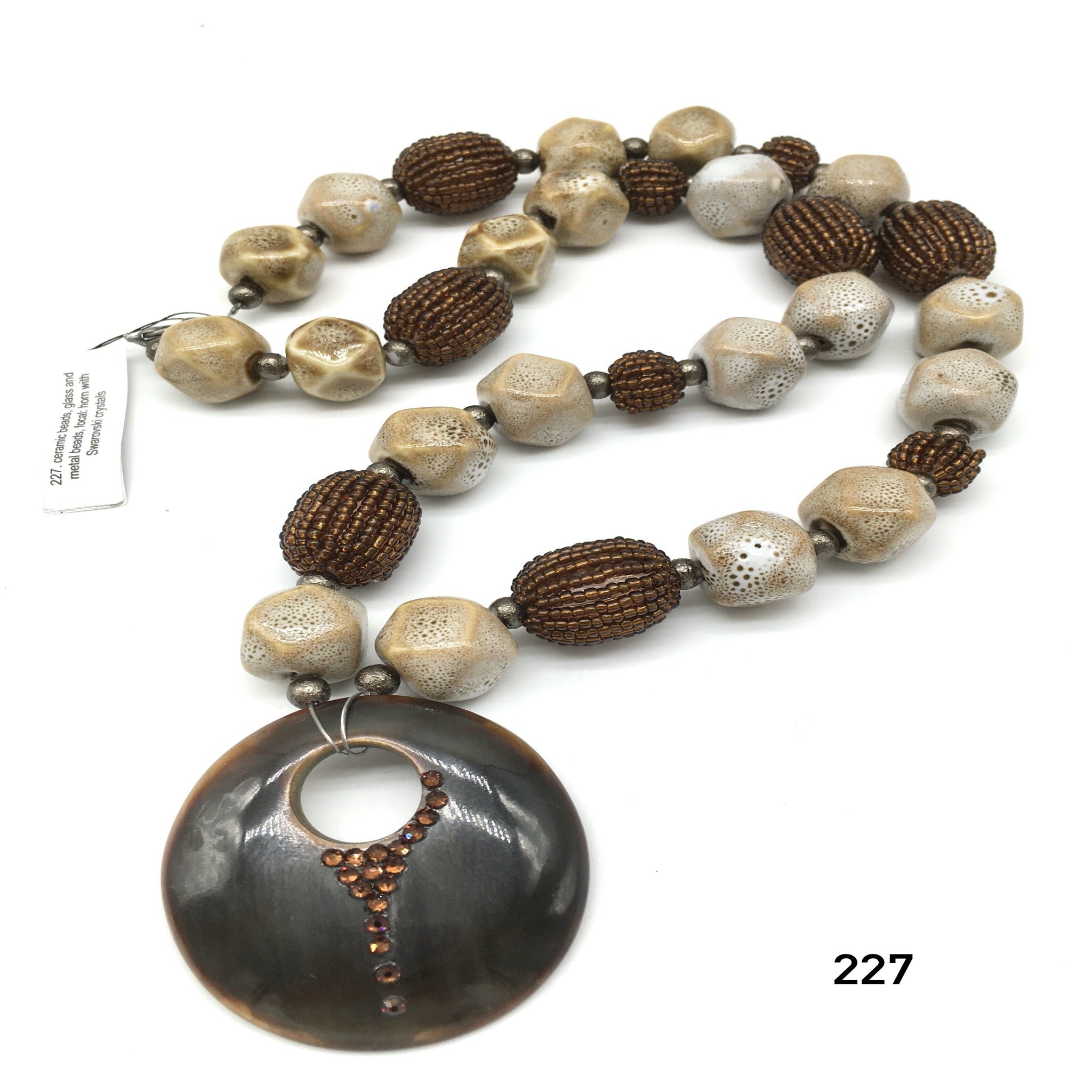 Ceramic beads, glass and metal beads, focal: horn with Swarovski crystals necklace created by Dorothea Drew Design central NJ
